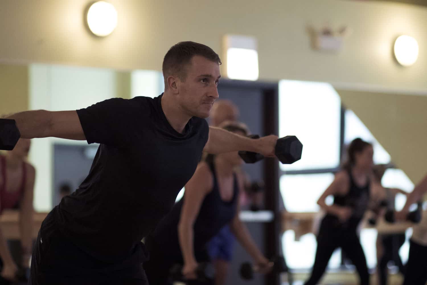 Man doing arm raises during a group fitness class at FFC.