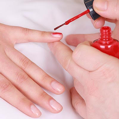 Woman getting her nails painted.
