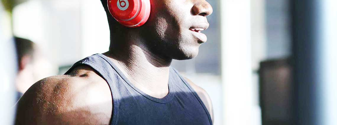 Man running on treadmill with headphones on listening to music