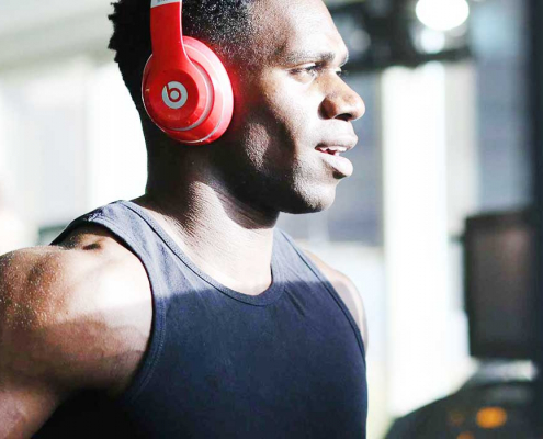 Man running on treadmill with headphones on listening to music