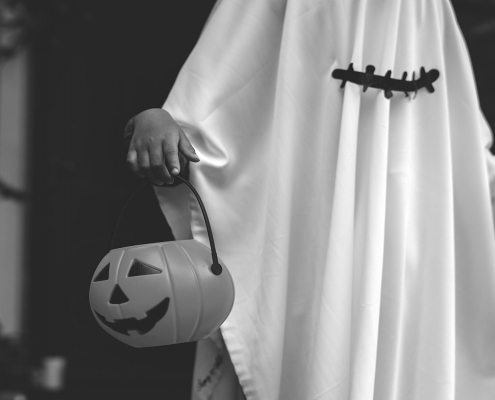 A person dressed up as a ghost trick or treating