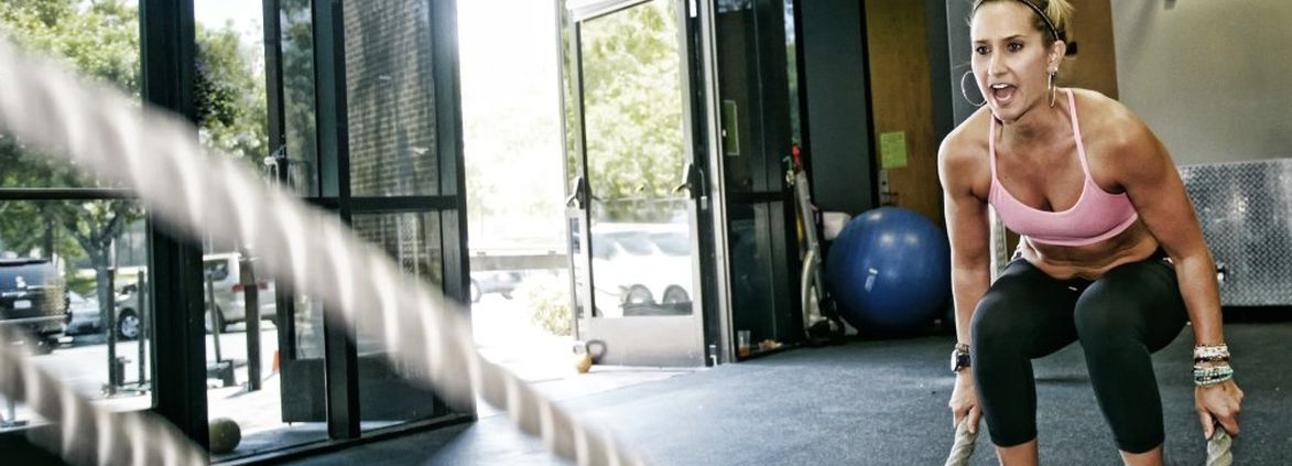 Woman working out with battle ropes.