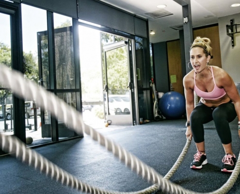 Woman working out with battle ropes.