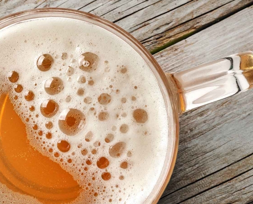 A beer on a wooden bench.