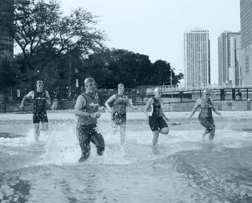 Trimonster participants running into Lake Michigan.