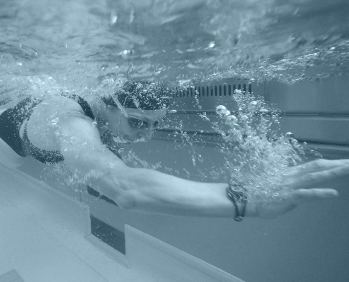 Side view of a woman swimming in a pool.