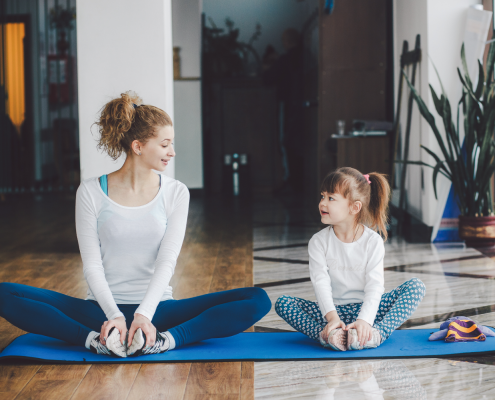 Woman and girl sitting together in yoga studio