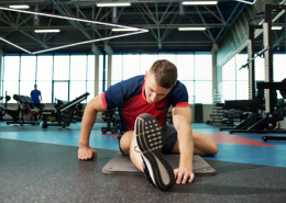 Man stretching on gym floor