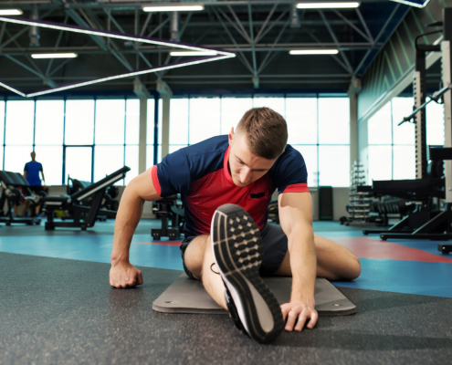 Man stretching on gym floor