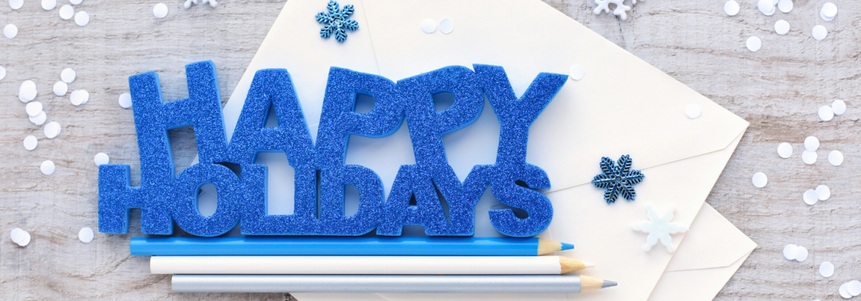 Happy Holidays graphic on a table with pencils and snowflakes