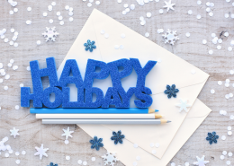 Happy Holidays graphic on a table with pencils and snowflakes