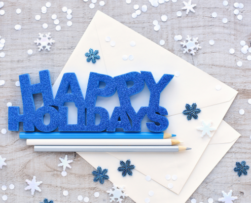 Happy Holidays graphic on a table with pencils and snowflakes