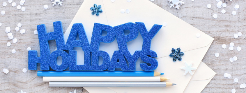 Happy Holidays graphic on a table with pencils and snowflakes