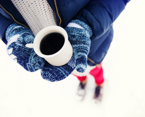 Girl in snow holding a coffee cup