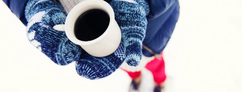 Girl in snow holding a coffee cup