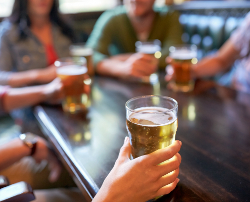 friends drinking beer and at bar or pub