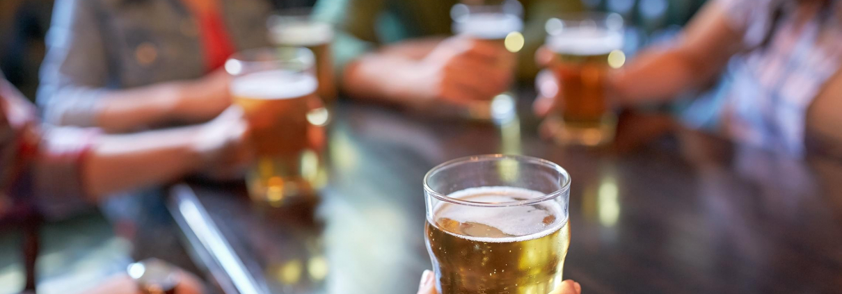 Image of friends drinking beer together in a bar.