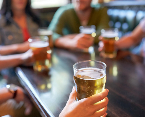 Image of friends drinking beer together in a bar.