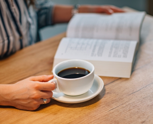 Woman drinking coffee and reading book