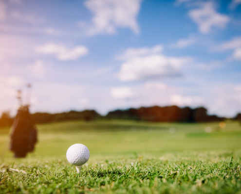 White golf ball on a green grass. Golf course. Summer luxury activities.