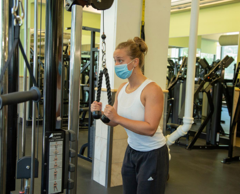 member wearing a mask exercising