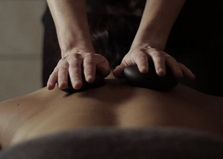 Client receiving a stone massage.