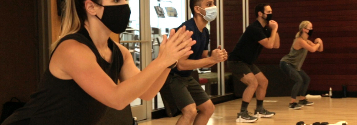Photo of a group fitness class in process with masks and social distancing