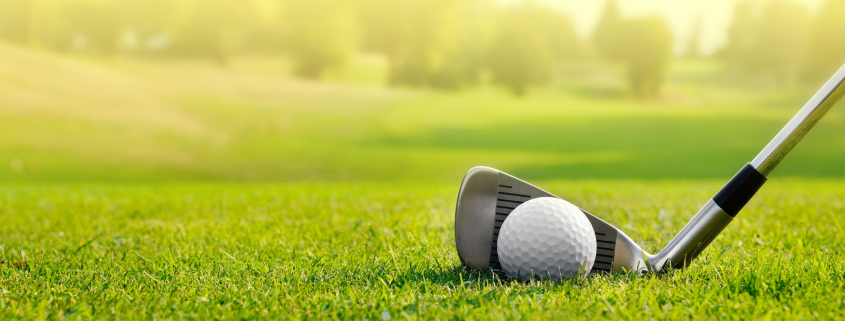 golf ball and club on putting green