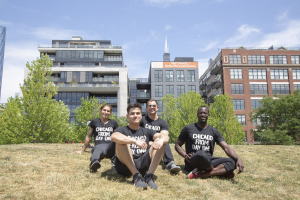 Group of FFC employees seated in grass with Willis Tower in background