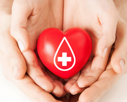 Two sets of hands holding a red heart