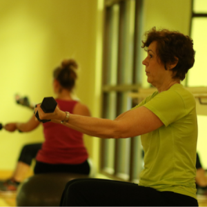 Woman lifting weights in a Fundamental Fitness group fitness class in Chicago