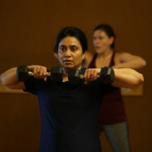 Woman lifting weights in a 20/20/20 group fitness class in Chicago