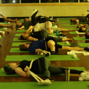 Men and women stretching with a strap in a Strength and Mobility group fitness class in Chicago