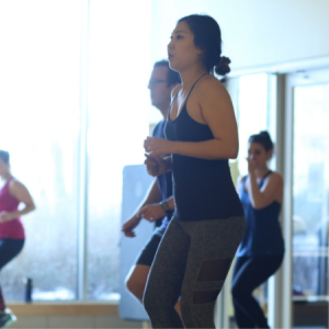 Woman jogging in place in a Total Body Blast group fitness class in Chicago