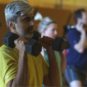Man lifting weights in an X Factor group fitness class in Chicago