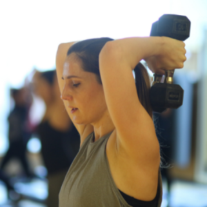Woman lifting weights in an Amped Up group fitness class in Chicago