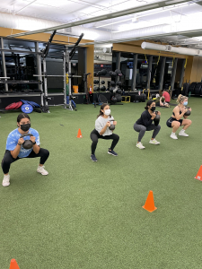 Participants in a kettlebell class performing a goblet squat