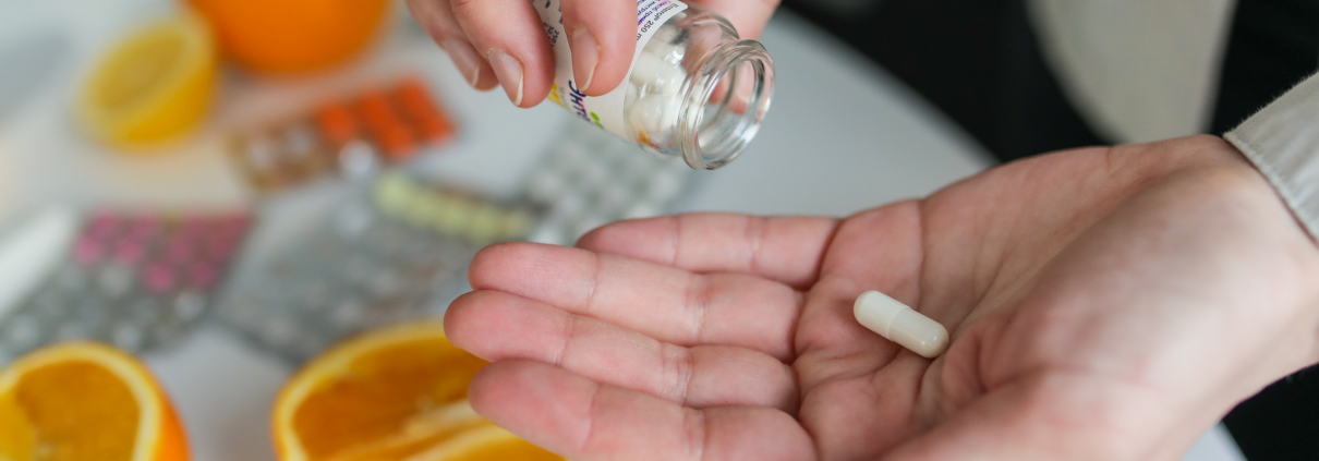 Person with a dietary supplement pill in their hand.