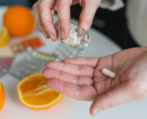 Person with a dietary supplement pill in their hand.