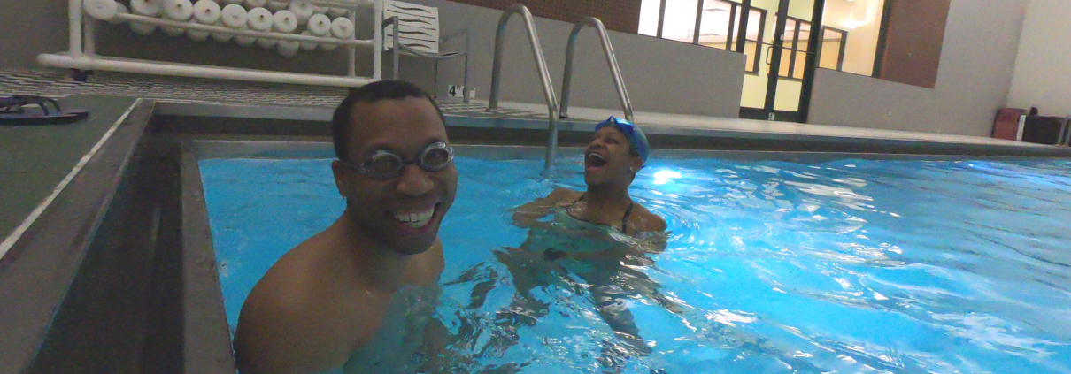 Juan smiling in pool with trainer Joy