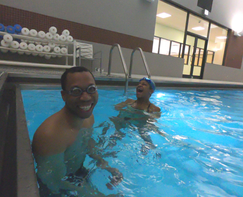 Juan smiling in pool with trainer Joy