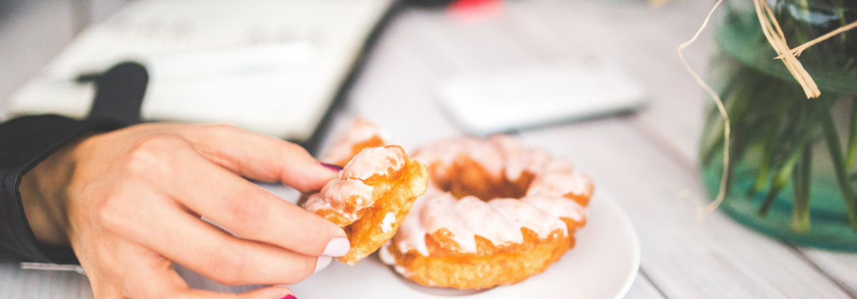 Photo of a hand reaching for a donut