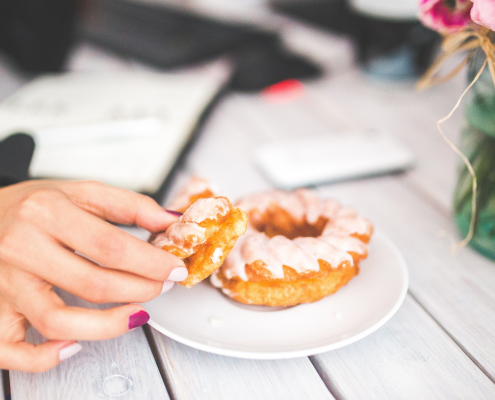 Photo of a hand reaching for a donut