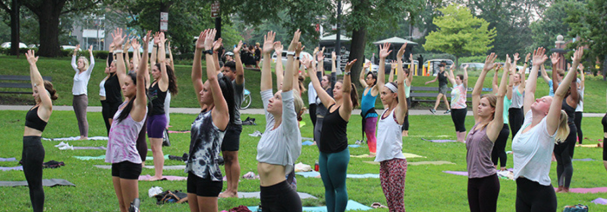 People in mountain pose in an outdoor yoga class