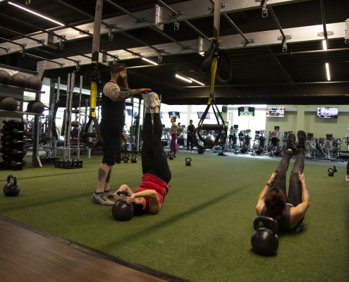 People exercising on turf at indoor gym