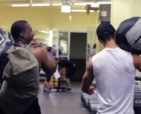 Friends walking together at a gym.