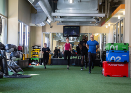 Image of 4 people running on indoor turf in a gym