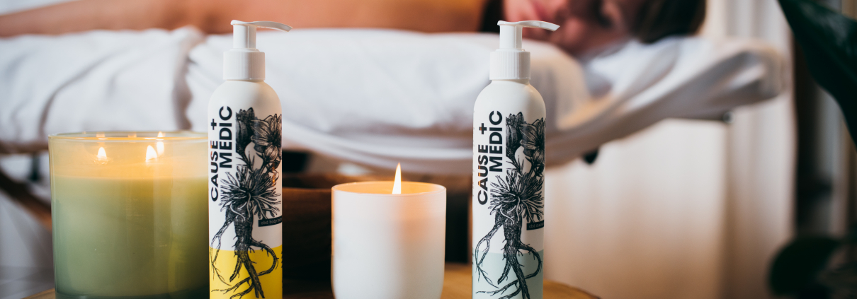 CBD Massage products displayed on a side table with a woman on a massage table in the background.