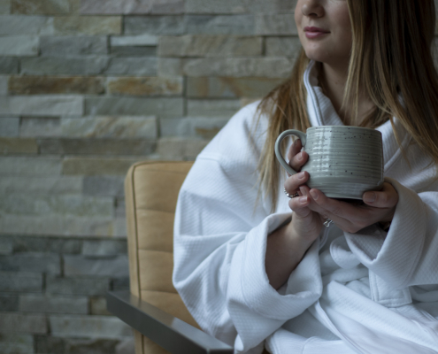 Woman sitting in arobe holding a coffee cup