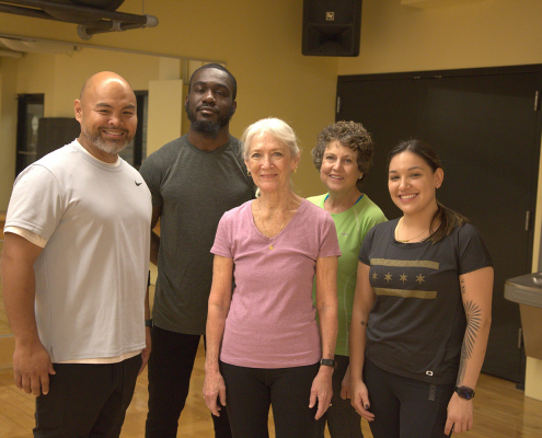 Group of people in a workout studio smiling at camera
